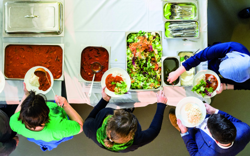 Junge Menschen stehen um ein Buffet