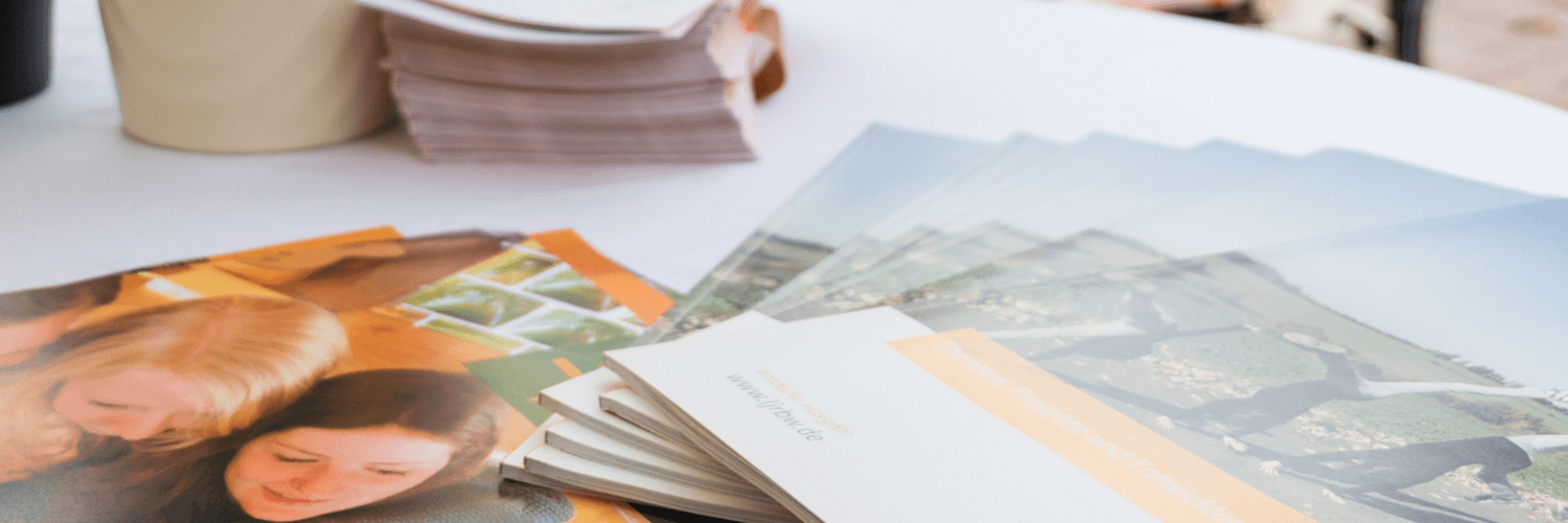 Auf einem Tisch liegen verschiedene Printprodukte des Landesjugendrings. Auf den Titelbildern sind Jugendliche bei verschiedenen Aktivitäten abgebildet.