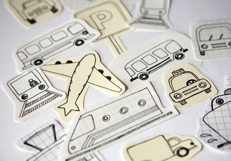 Auf einem weißen Hintergrund sind viele verschiedene hangezeichnete Transportmittel aufgezeichnet wie Bus und Bahn.