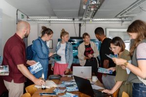 Viele Menschen stehen um einen Tisch, an dem sich ein Projekt vorstellt.